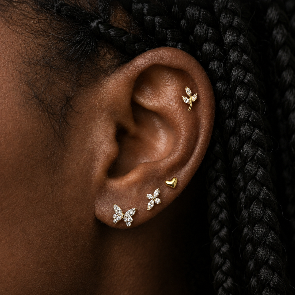 close up van oor met gouden sieraden en zwart haar