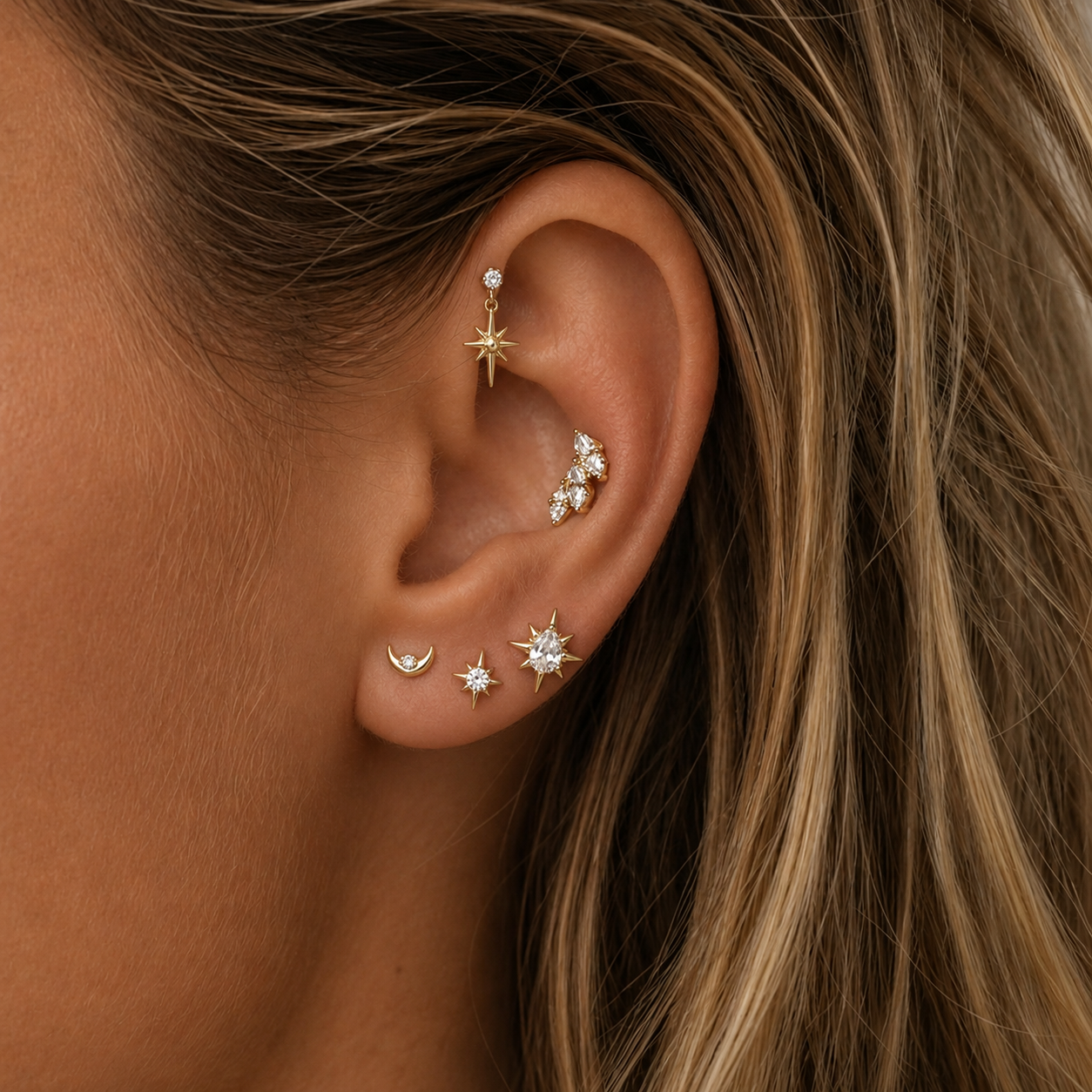 close up van oor met gouden sieraden en blond haar