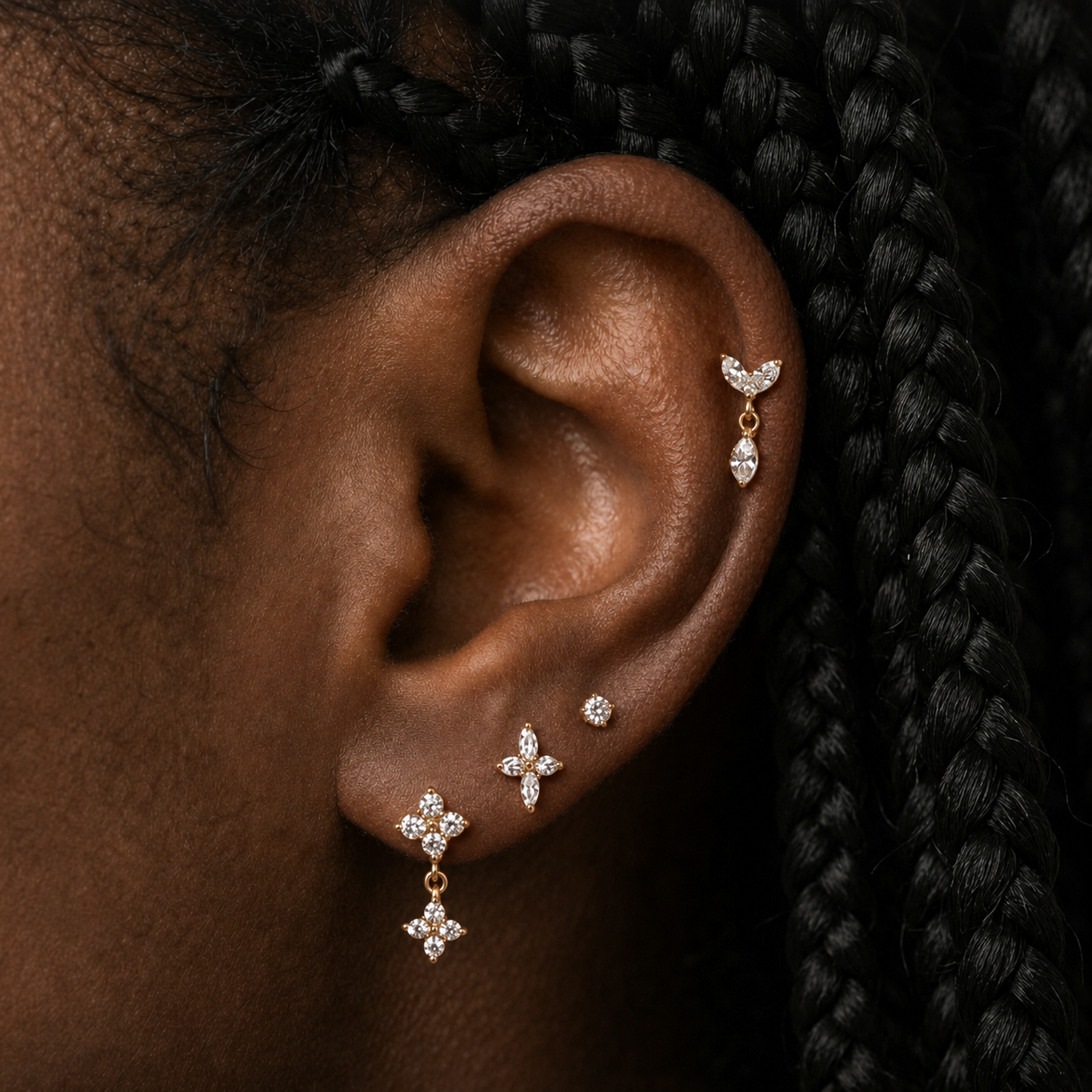 close up van oor met gouden sieraden en zwart haar