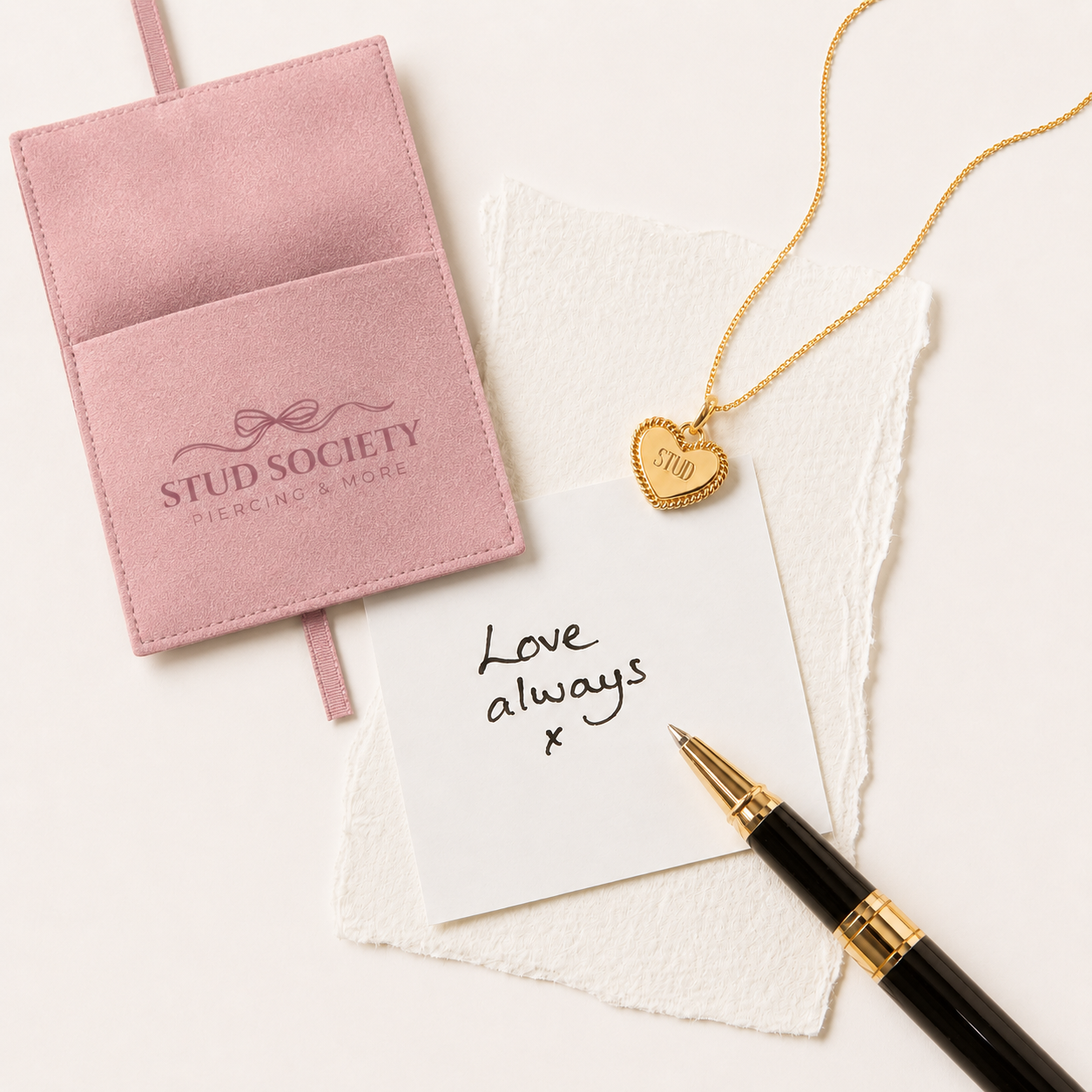 roze pouch met gouden sieraad en pen met love note
